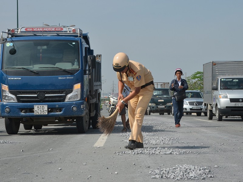 Cảnh sát giao thông đội nắng dọn đá rơi vãi trên đại lộ - ảnh 1